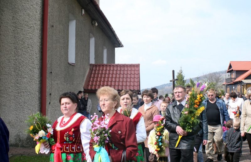 Panie w strojach regionalnych z palmami.