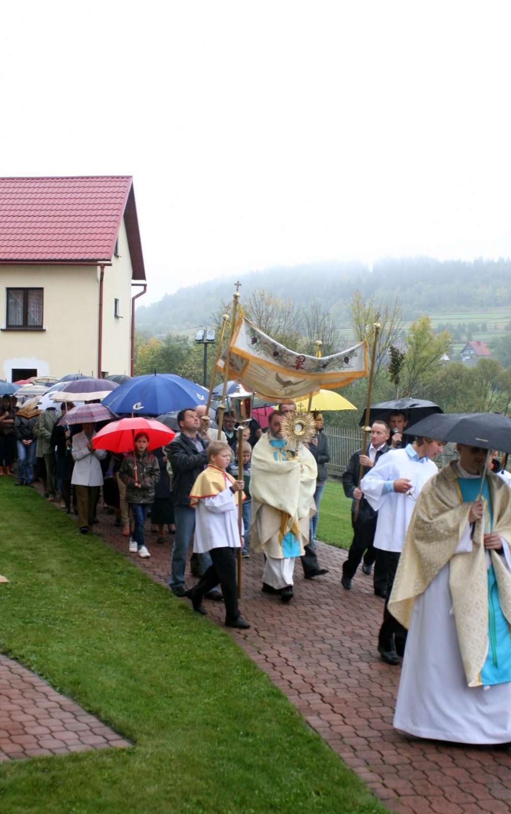 Procesja na tle wzgórz.