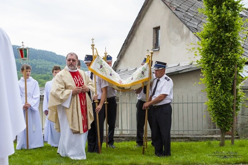 Kapłan z monstrancją pod baldachimem.
