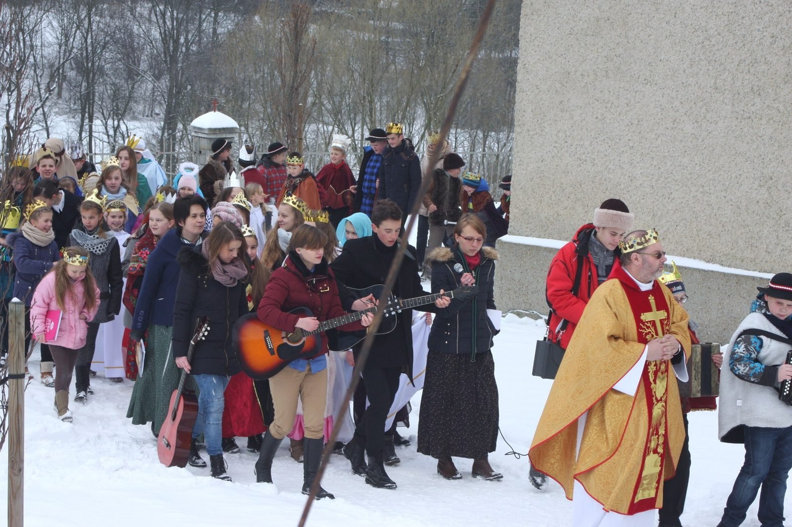 Orszak z gitarą przy kościele.