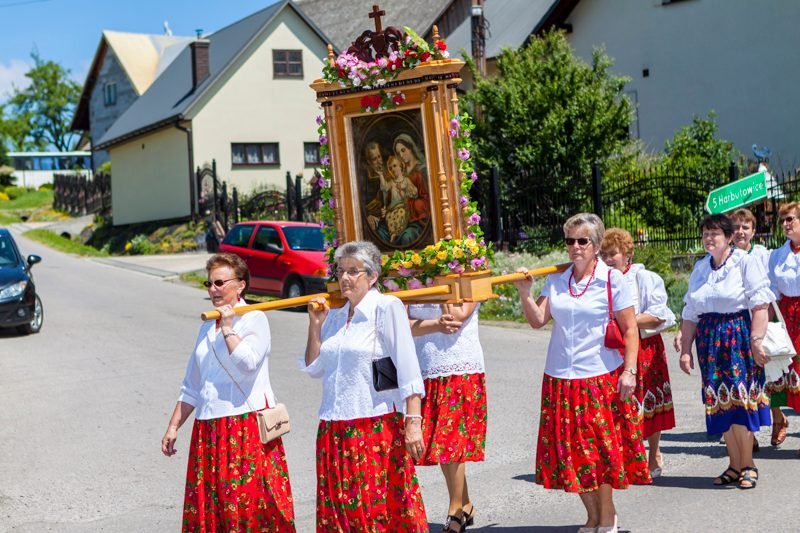 Feretron niesiony przez panie w strojach regionalnych.