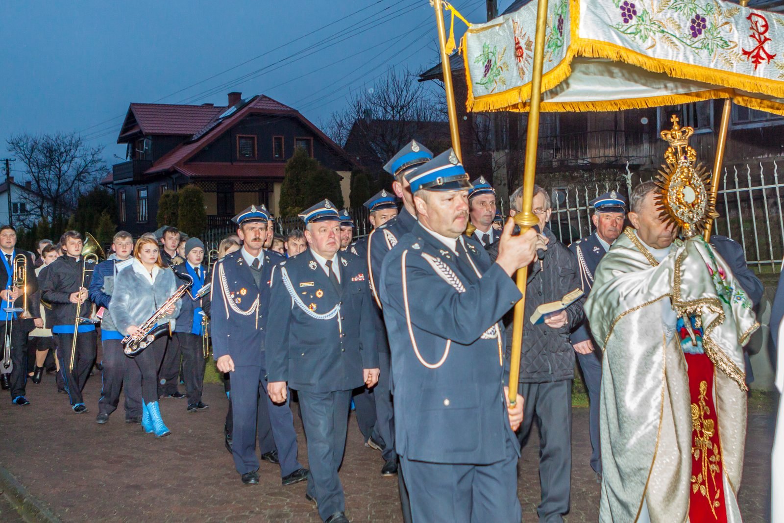 Kapłan z monstrancją pod baldachimem.