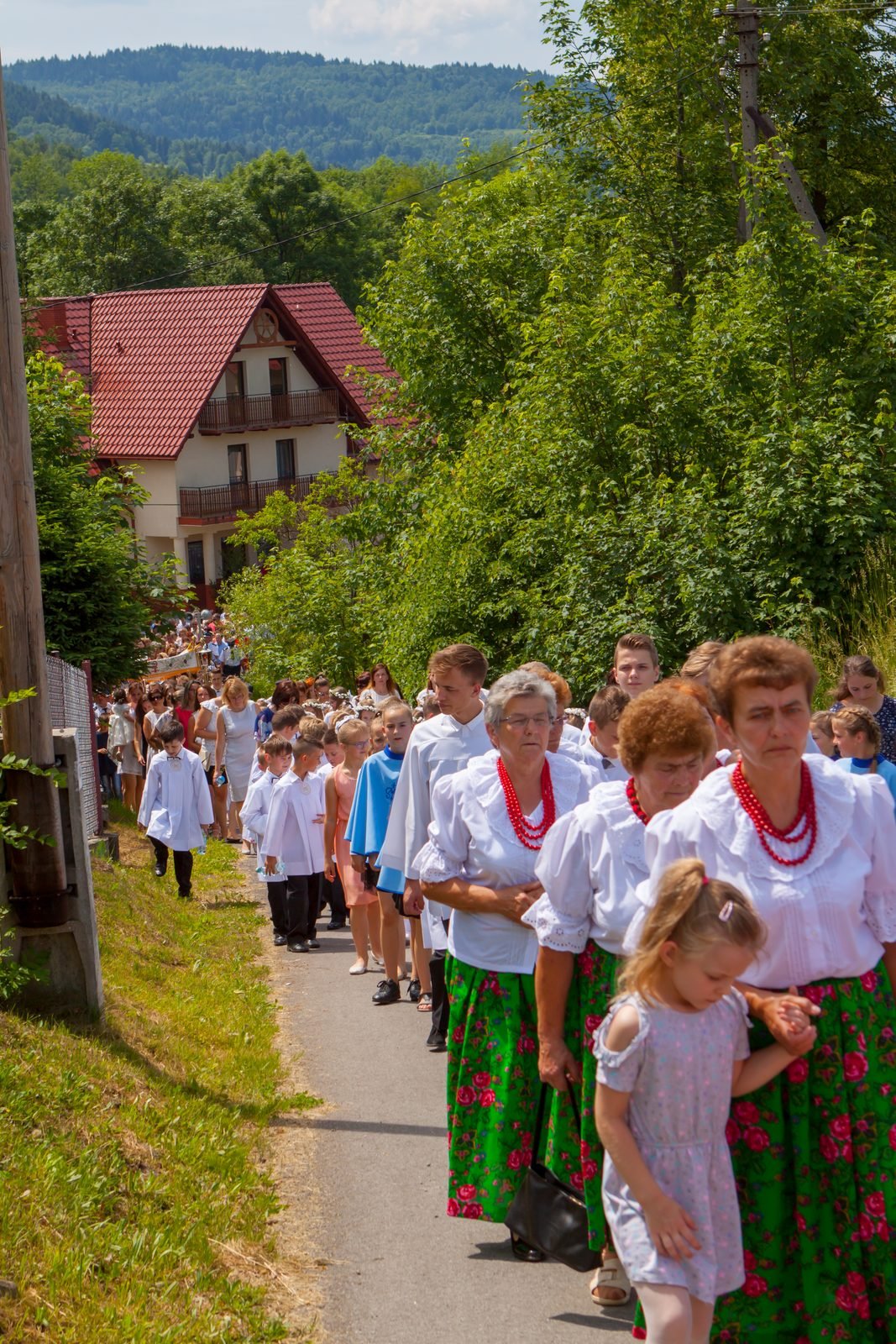 Panie w strojach regionalnych w procesji.