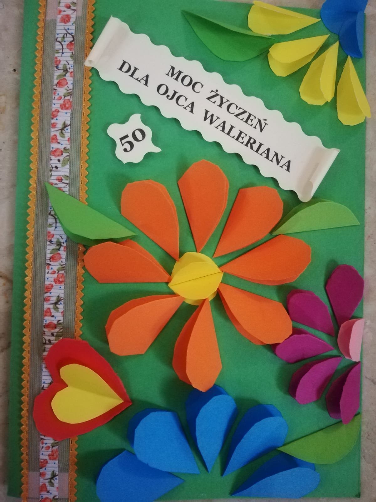 „Moc życzeń dla Ojca Waleriana”: kwiaty i serca z papieru.