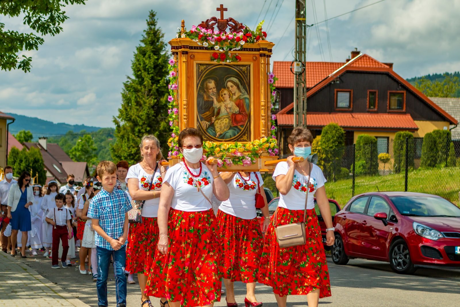 Feretron niesiony przez panie w strojach regionalnych.