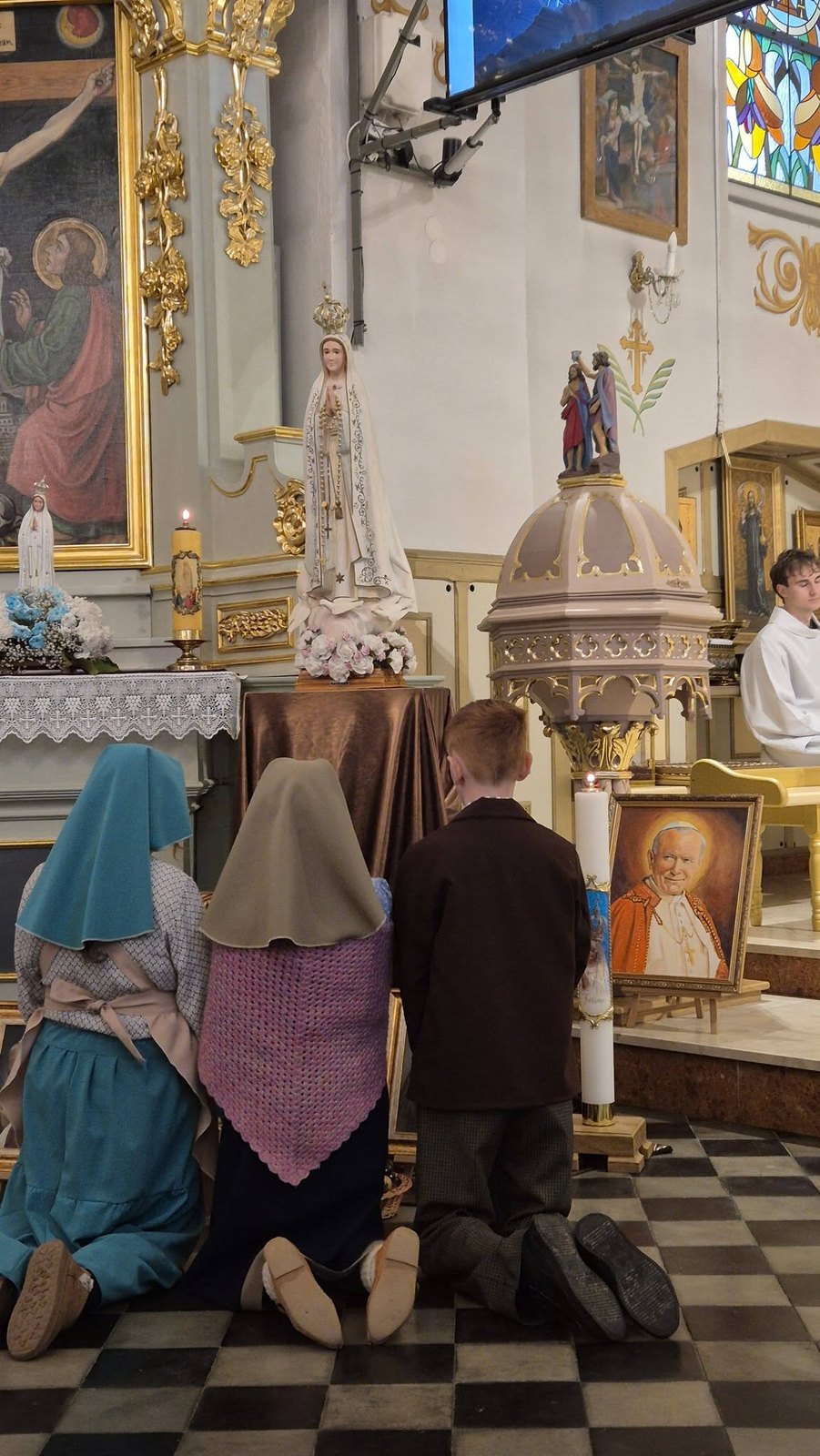 Pastuszkowie z Fatimy – w tej roli dzieci z parafii – na modlitwie przed figurą Matki Bożej Fatimskiej.